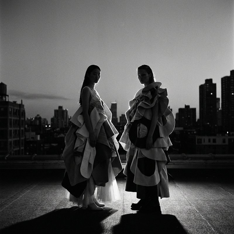 Editorial fashion, two models on rooftop, rim light silhouettes